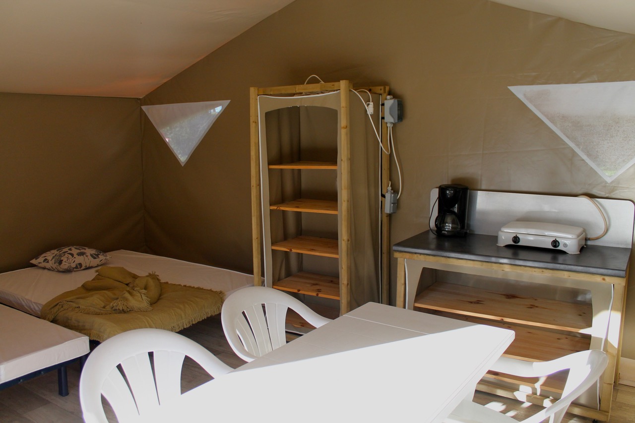 Intérieur d’un lodge avec lits, kitchenette et table à manger, Camping Le Dauphin